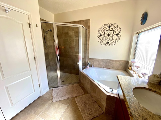 bathroom featuring tile patterned floors, vanity, and plus walk in shower