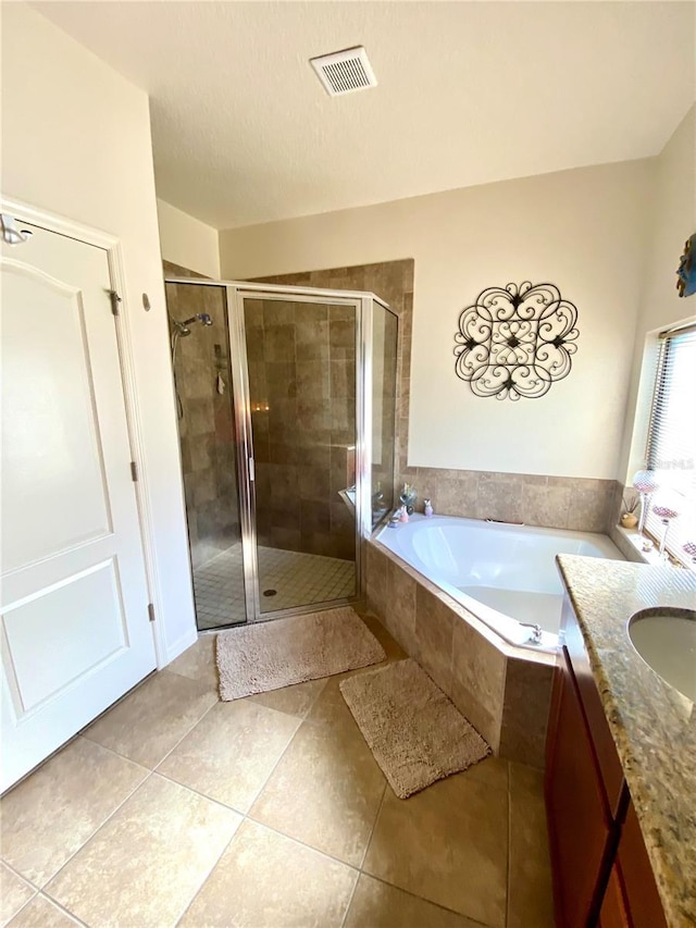 bathroom with tile patterned floors, vanity, and separate shower and tub