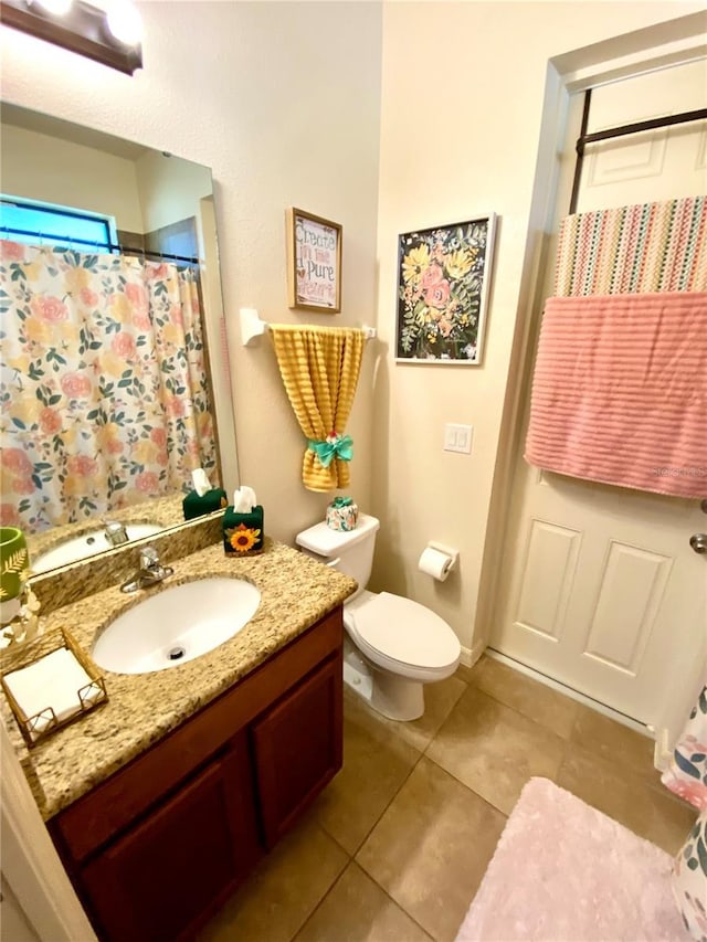 bathroom featuring tile patterned floors, vanity, and toilet