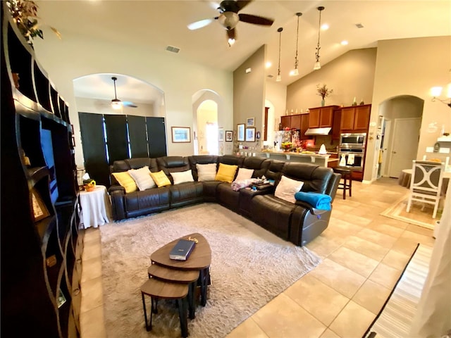 tiled living room featuring high vaulted ceiling and ceiling fan