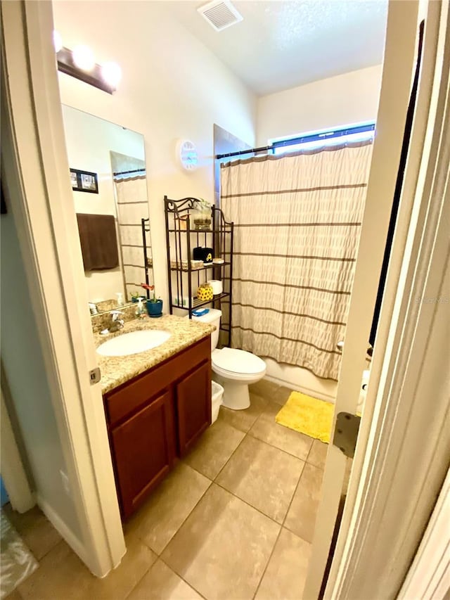 full bathroom with tile patterned floors, vanity, toilet, and shower / bath combo