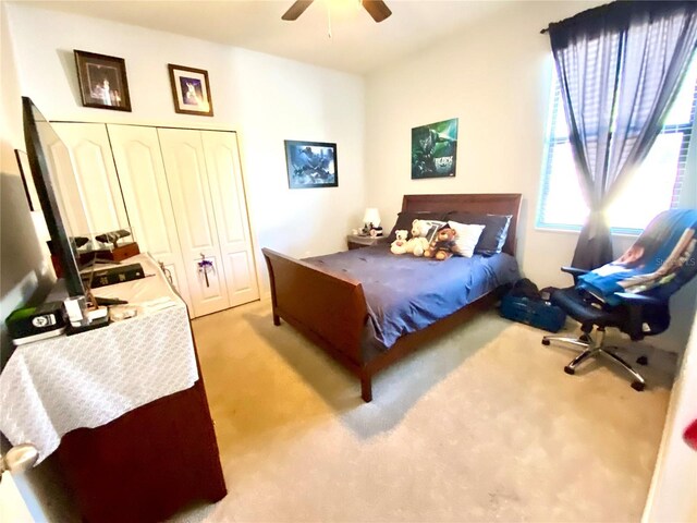 carpeted bedroom with ceiling fan and a closet