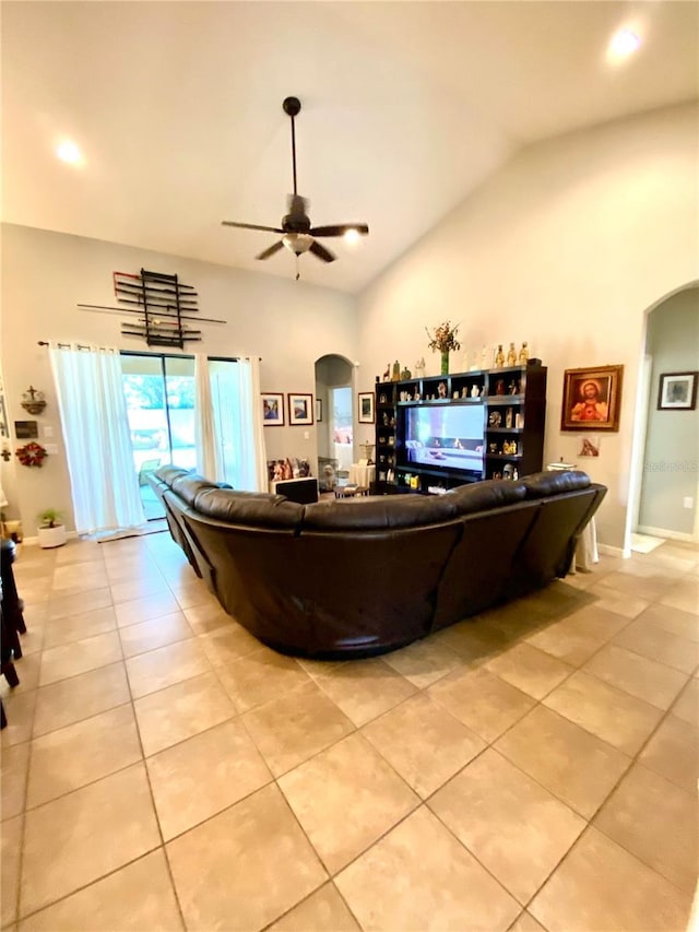 tiled living room featuring ceiling fan and lofted ceiling