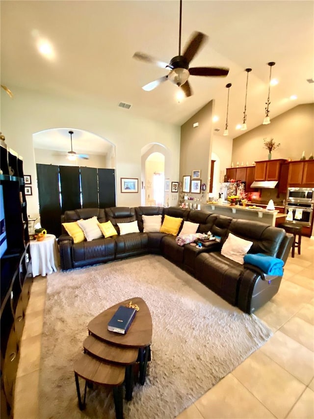 living room featuring ceiling fan, light tile patterned flooring, and lofted ceiling