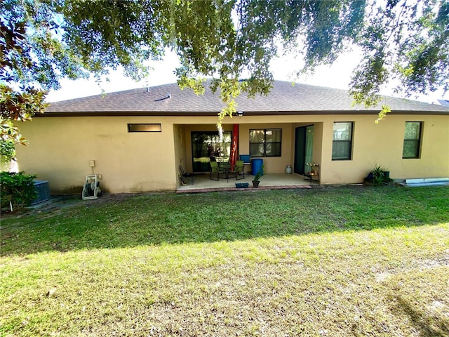 rear view of house featuring a patio area and a lawn