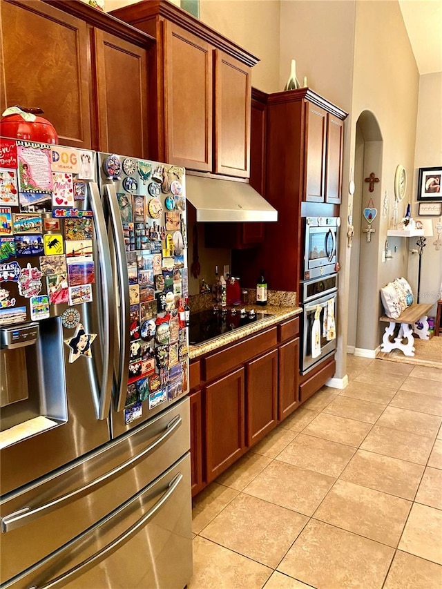 kitchen featuring light stone countertops, appliances with stainless steel finishes, and light tile patterned floors