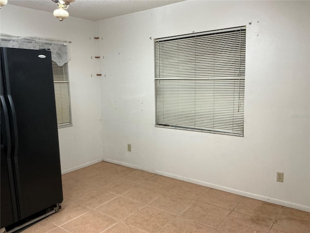 empty room featuring a textured ceiling and light tile patterned flooring