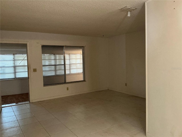 unfurnished room featuring a textured ceiling