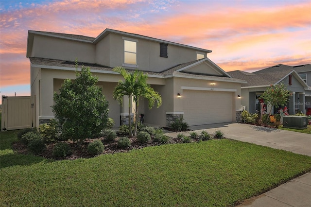 view of front of home with a garage and a lawn