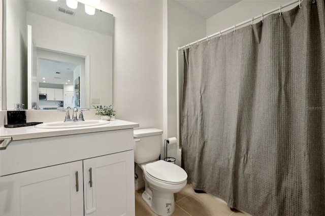 bathroom featuring tile patterned flooring, vanity, and toilet