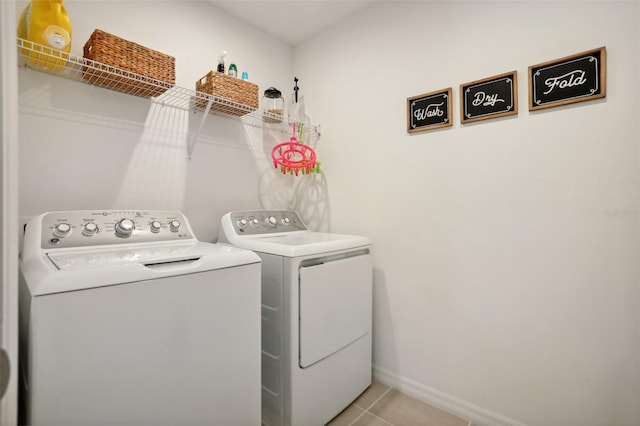 laundry area with washer and dryer and light tile patterned floors