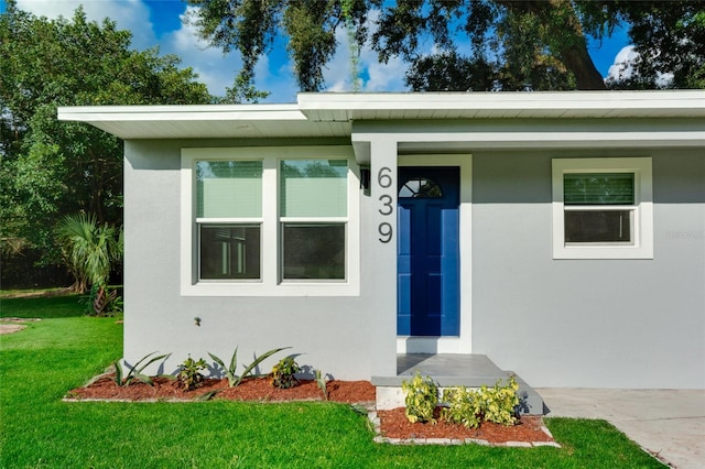 entrance to property featuring a yard