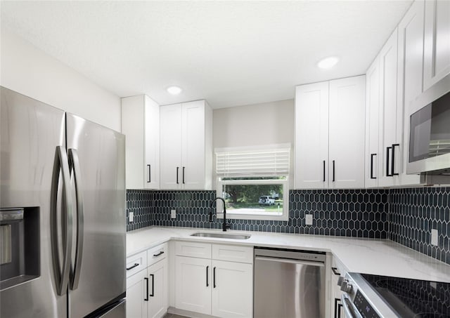 kitchen featuring white cabinetry, sink, decorative backsplash, and appliances with stainless steel finishes