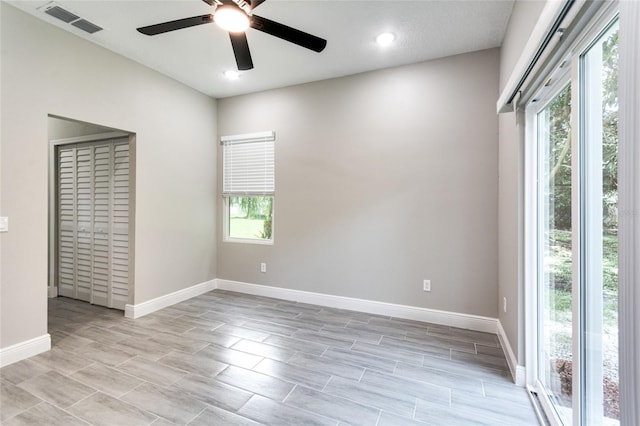 empty room with light hardwood / wood-style floors, ceiling fan, and a textured ceiling