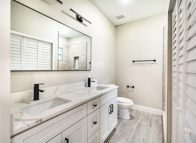 bathroom featuring toilet, vanity, and wood-type flooring