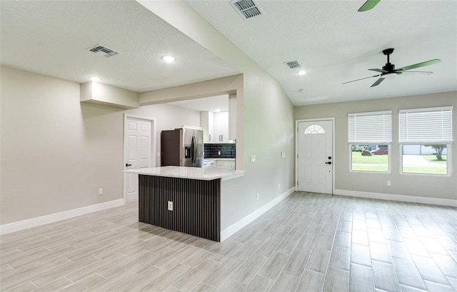 kitchen featuring kitchen peninsula, stainless steel fridge with ice dispenser, light hardwood / wood-style floors, and white cabinets