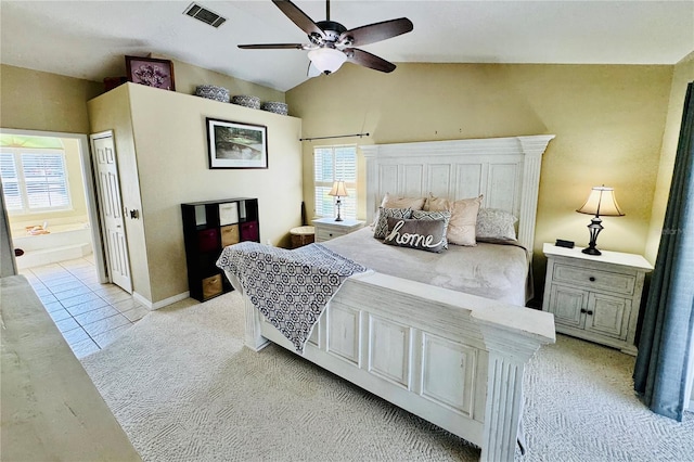 tiled bedroom featuring ensuite bathroom, ceiling fan, and vaulted ceiling