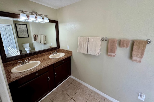 bathroom with tile patterned floors, vanity, and toilet