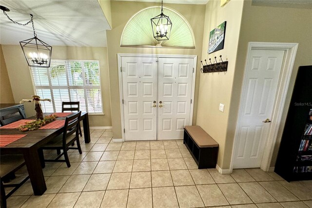 tiled foyer entrance with a notable chandelier