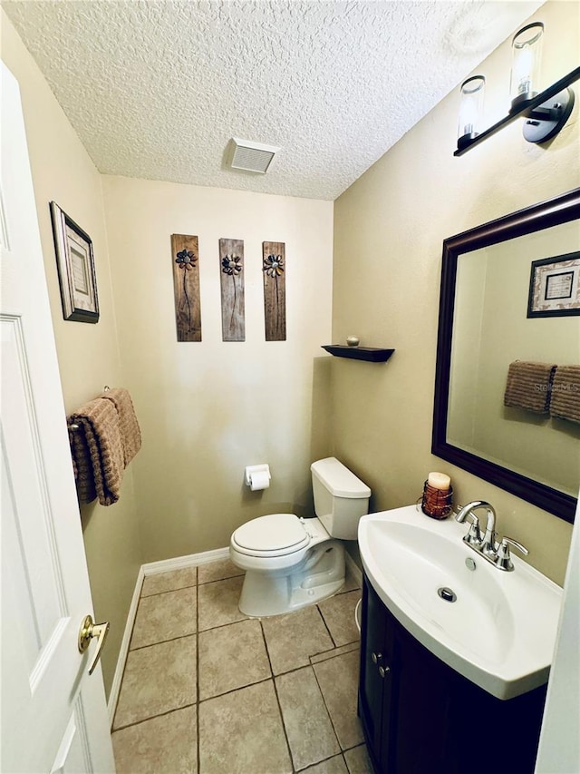 bathroom featuring vanity, a textured ceiling, tile patterned floors, and toilet