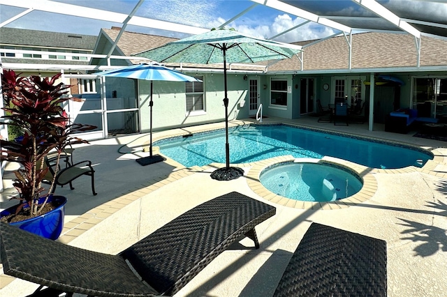 view of pool with glass enclosure, an in ground hot tub, and a patio