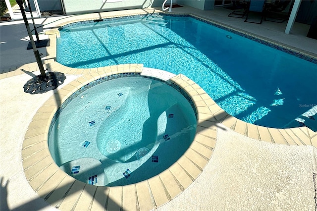 view of pool featuring an in ground hot tub and a patio