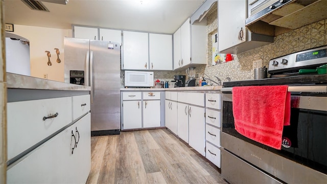 kitchen featuring decorative backsplash, white cabinetry, light hardwood / wood-style flooring, and stainless steel appliances