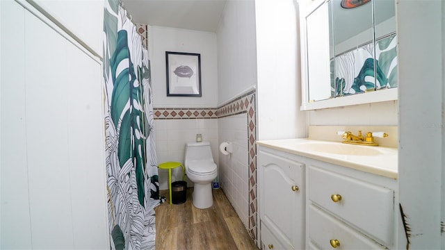 bathroom with toilet, vanity, tile walls, and hardwood / wood-style flooring