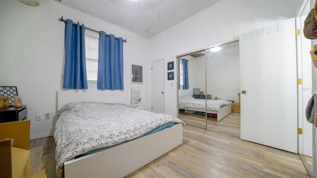 bedroom featuring ceiling fan, a closet, and light hardwood / wood-style flooring