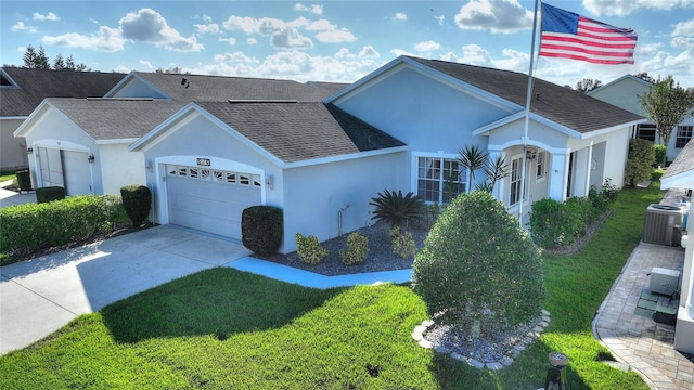 ranch-style home featuring a front yard, a garage, and cooling unit