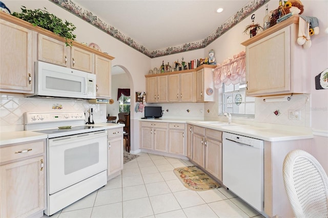 kitchen with sink, light brown cabinets, light tile patterned floors, tasteful backsplash, and white appliances