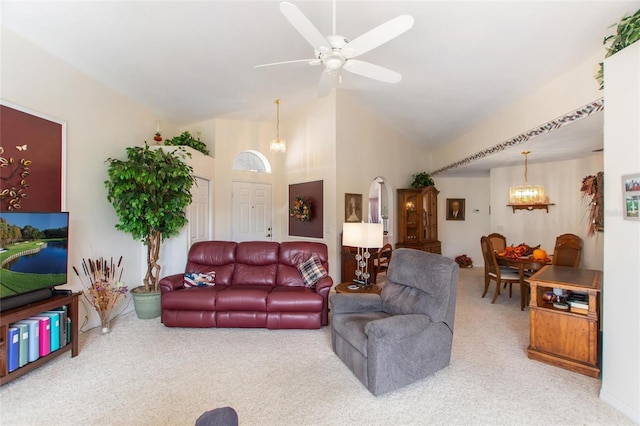 carpeted living room featuring high vaulted ceiling and ceiling fan with notable chandelier