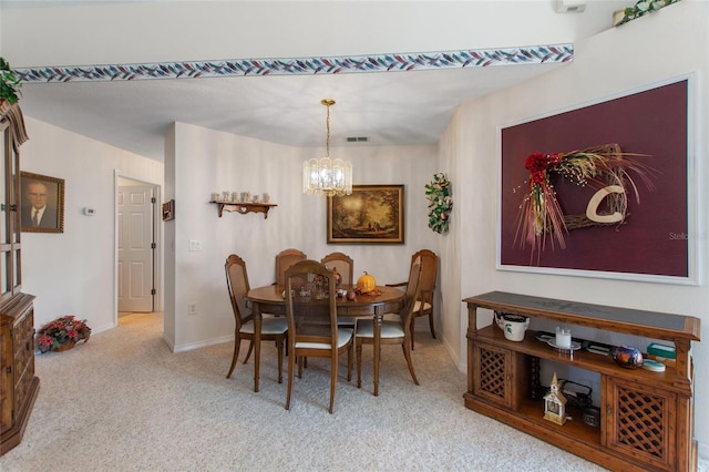 dining space featuring light colored carpet and an inviting chandelier