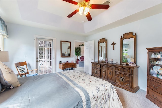 bedroom with access to outside, ceiling fan, a raised ceiling, and light carpet