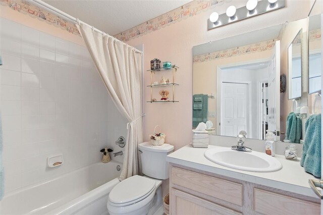 full bathroom with shower / bath combo with shower curtain, vanity, a textured ceiling, and toilet