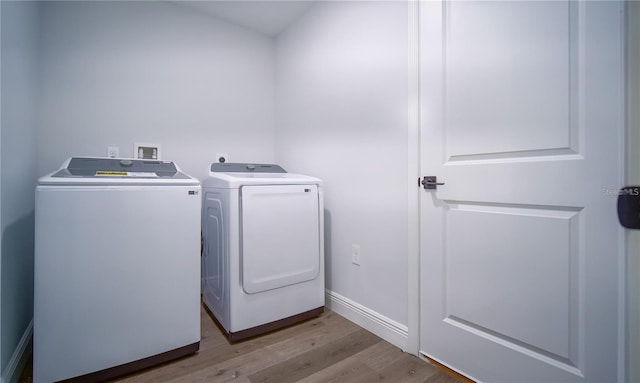 washroom with light hardwood / wood-style floors and independent washer and dryer