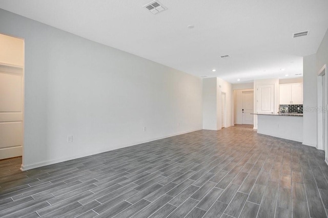 unfurnished living room featuring dark wood-type flooring