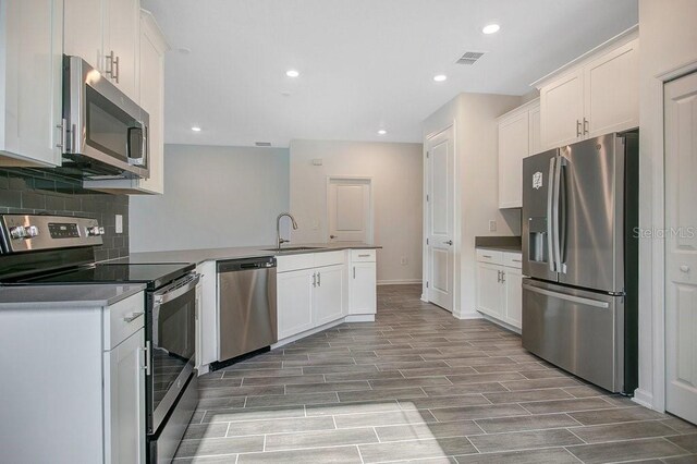 2971 Camden Way, Davenport, FL 33837 - kitchen with stainless steel appliances, a peninsula, white cabinetry, backsplash, and recessed lighting