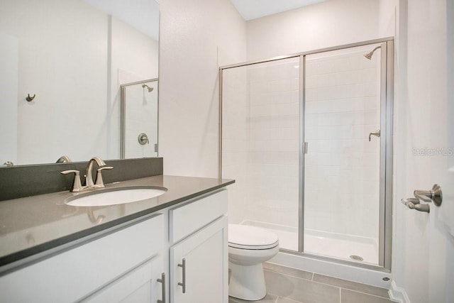 bathroom featuring tile patterned flooring, vanity, toilet, and a shower with door