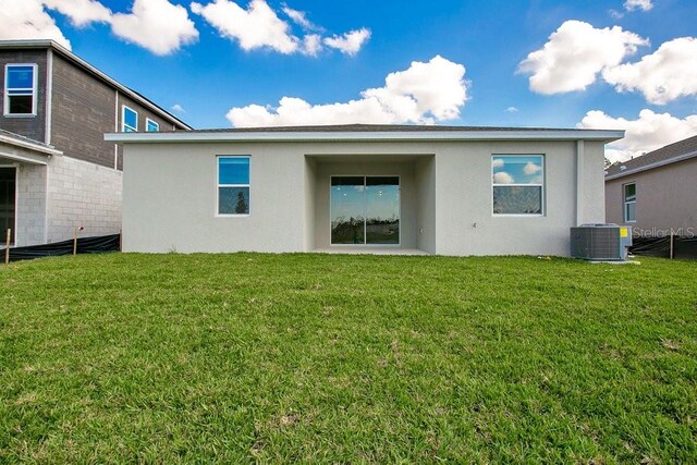 2971 Camden Way, Davenport, FL 33837 - rear view of property with stucco siding, central AC unit, and a yard