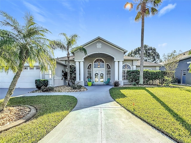 view of front of home with a front yard, french doors, and a garage