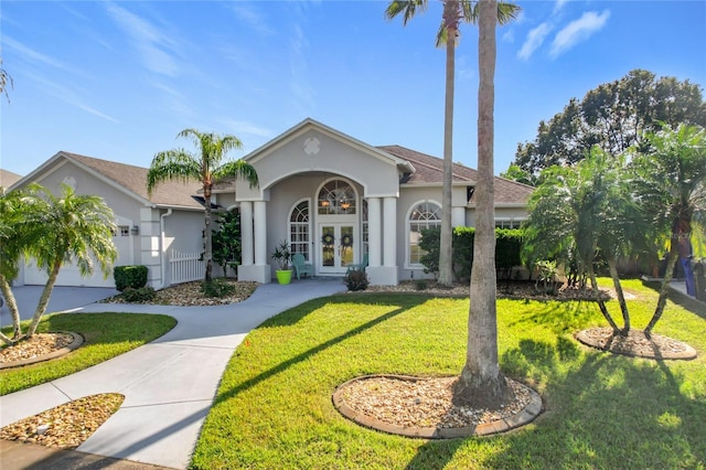 view of front facade featuring french doors, a front yard, and a garage