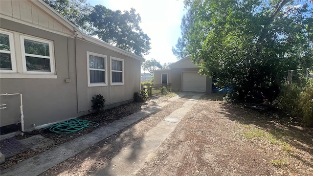 view of property exterior featuring a garage and an outbuilding