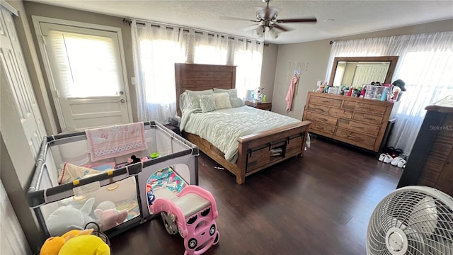 bedroom featuring a textured ceiling, dark hardwood / wood-style flooring, and ceiling fan