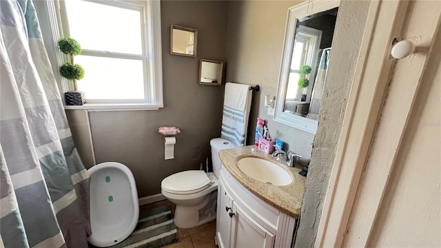 bathroom featuring tile patterned flooring, vanity, and toilet