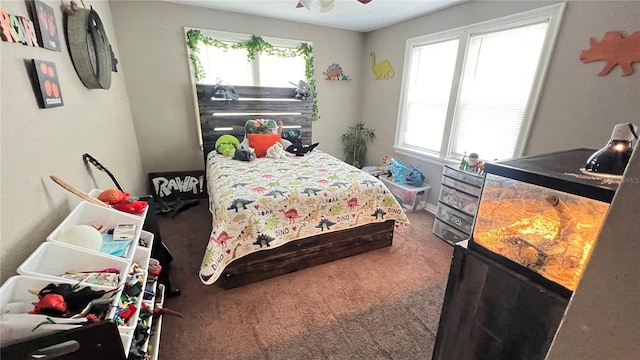 bedroom with multiple windows, ceiling fan, and carpet floors