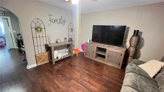 living room featuring dark wood-type flooring and ceiling fan