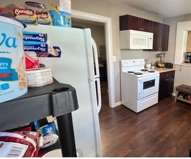 kitchen featuring dark wood-type flooring, white appliances, and dark brown cabinets