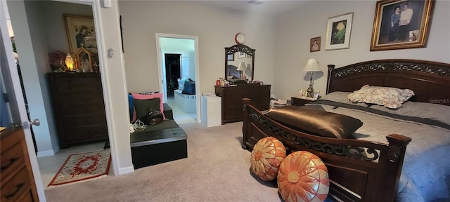 carpeted bedroom featuring ensuite bath