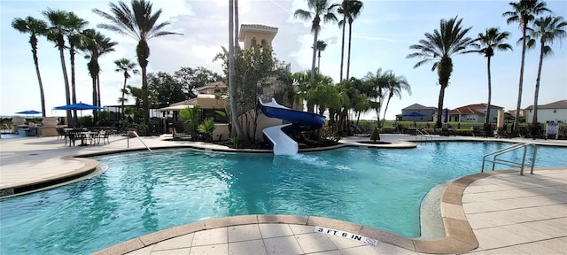 view of swimming pool featuring a water slide and a patio area